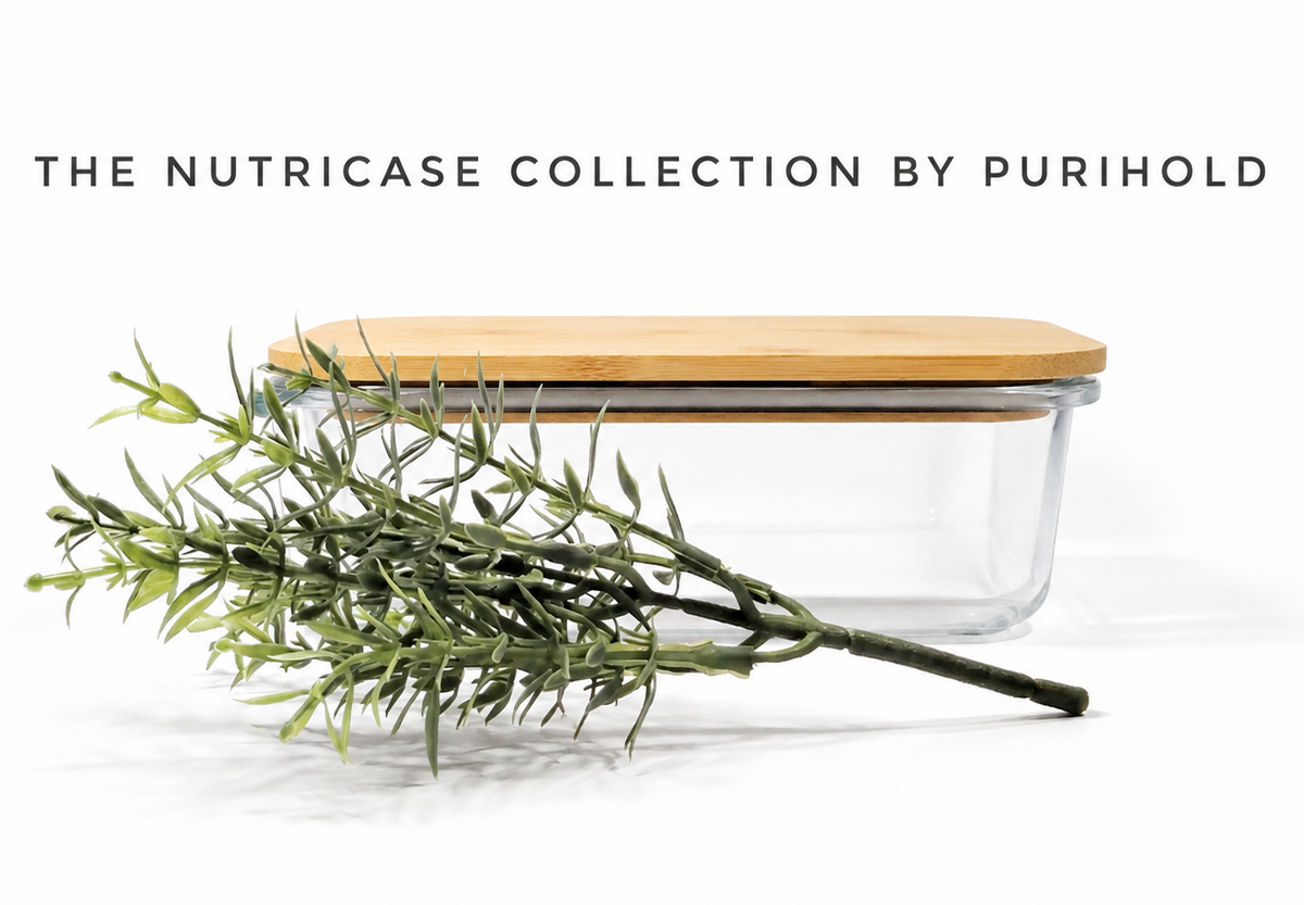 A clear glass rectangular container with a light real bamboo lid, shown on a white background with decorative green branches in front. Text at the top reads 'THE NUTRICASE COLLECTION BY PURIHOLD'.